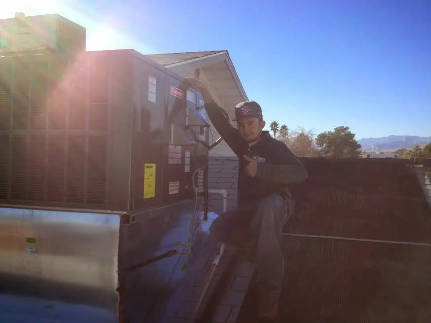 HVAC technician performing HVAC Inspection on a rooftop unit in Hartland